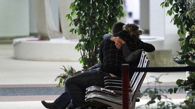 Emotional ... relatives of victims of the bus crash sit on a bench at a hospital in Sion.