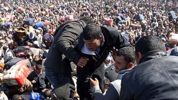 Border chaos ... Egyptian workers attempt to enter Tunisia after fleeing Libya. Tens of thousands of refugees remain trapped in Libya, and the UN says the situation is reaching "crisis point".