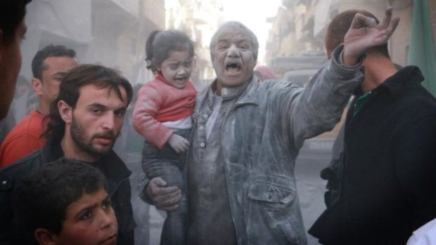 A Syrian man holds a crying girl as he gestures following an air strike by government forces on the Sahour neighbourhood of the northern Syrian city of Aleppo.