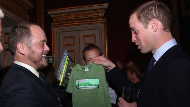 Conservationist Sean Willmore gives Prince William a T-shirt for the baby on the way.