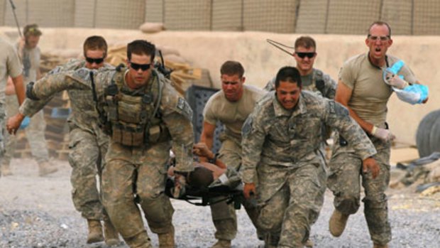 Soldiers carry a critically wounded American colleague near Kandahar.