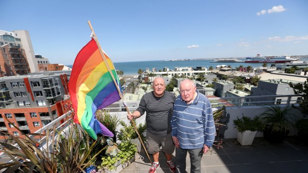 James Bellia and Murray Sheldrick on the balcony of their Port Melbourne apartment, after being told to stop flying their flag.