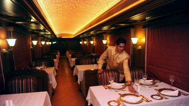 An Indian train assistant arranges a table setting in the restaurant of the Maharajas' Express, the first pan-India super luxury train.