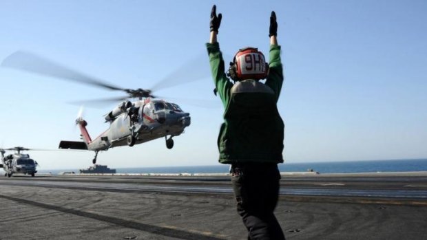 A US Navy Sea Hawk helicopter lands on the USS George H.W. Bush.