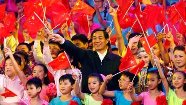 Bo Xilai waves a Chinese flag during a "red songs" patriotic singing event.