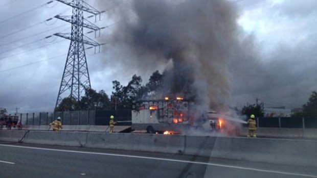 Fire crews extinguish a blazing vehicle on the Monash Freeway.