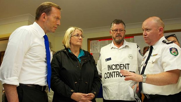 NSW RFS Commissioner Shane Fitzsimmons (far right) briefs Prime Minister Tony Abbott, Superintendent David Jones and local MP Louise Markus at Winmalee last week.