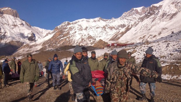 A survivor is carried to safety by Nepalese soldiers.