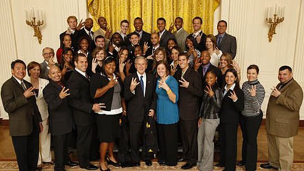 George W Bush performs the 'Pitchfork' with members of the Arizona State men's and women's track teams at the White House.