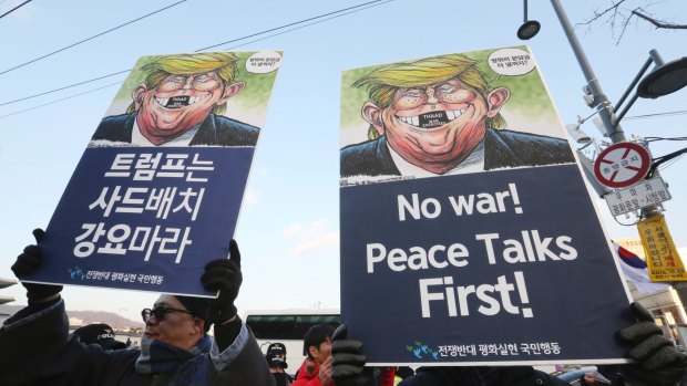South Korean protesters hold up cartoons depicting US President Donald Trump during a rally against US Defence Secretary Jim Mattis' visit.