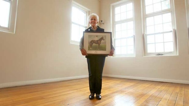 Lorraine Cove holds a portrait of her late husband Norm's favourite race horse Ajax.