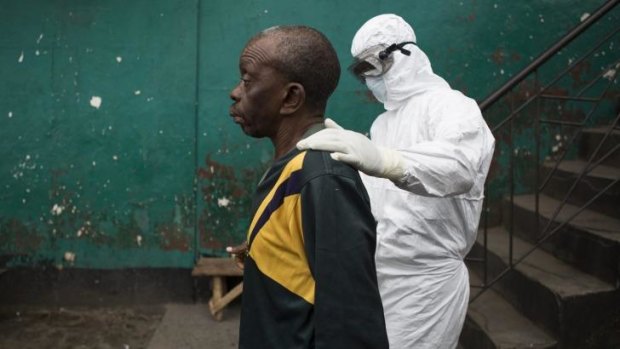 Infection control: A health worker with a man suspected to be infected with Ebola.
