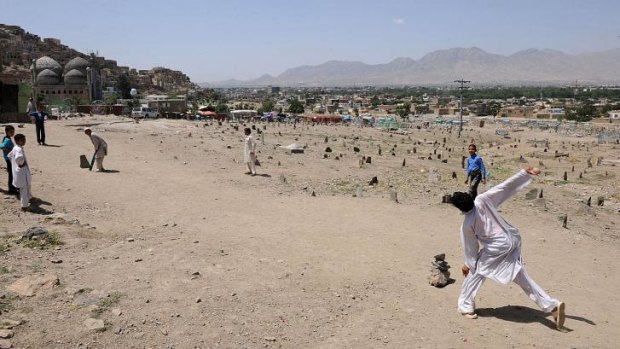 Afghan boys play cricket near a cemetery in Kabul. Attacks on people participating in sport were common when the Taliban ruled Afghanistan.