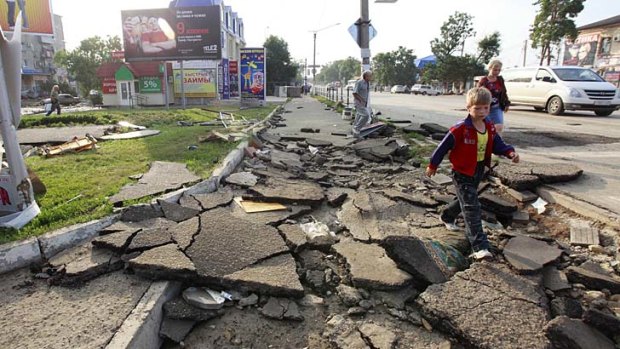 Local residents walk along a street in Krymsk that was damaged by the floods.