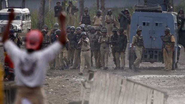 A Kashmiri protester gestures towards Indian policemen during an anti-India protest in Srinagar on Tuesday.