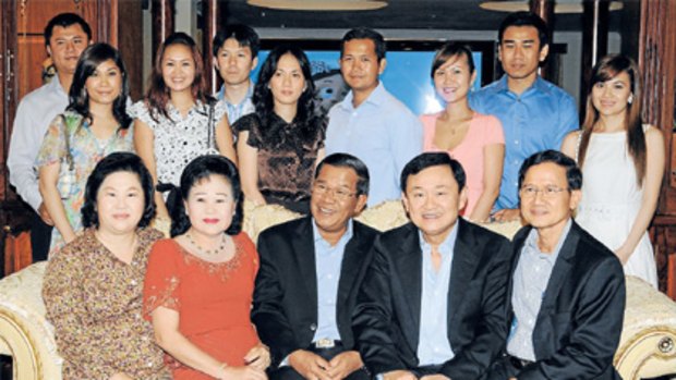 Family friend: Thaksin Shinawatra (seated, second right) with Cambodian PM Hun Sen (front centre) and relatives.