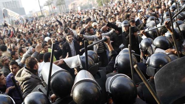 Anti-government protesters demonstrate near riot police at Tahrir Square in downtown Cairo.
