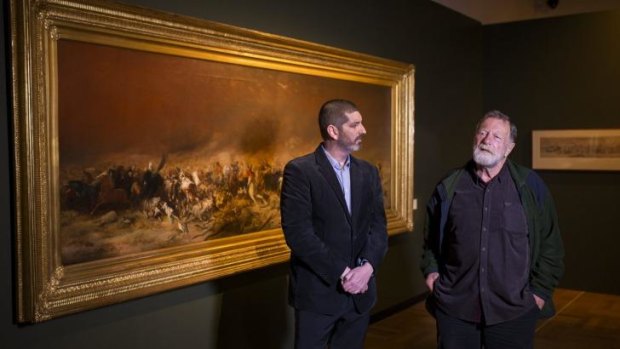 Currator Matthew Jones talks with actor Jack Thompson in front of Black Thursday at the launch the National Library of Australia's new exhibition Heroes and Villains: Strutt's Australia.
