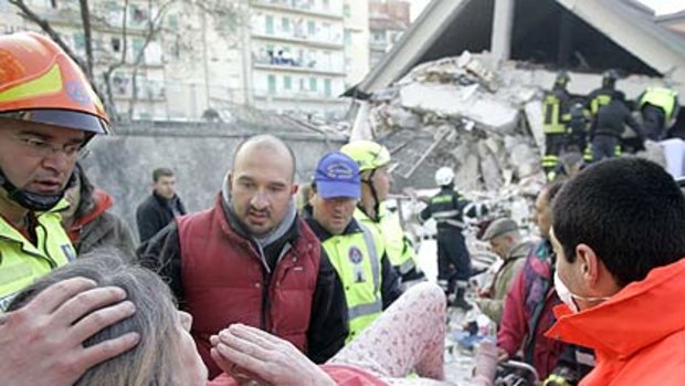 A "terrifying, bloody dawn''  . . . rescuers treat a woman injured in the earthquake that devastated the central Italian town of L'Aquila.