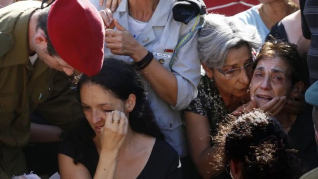 The wife (second from left) and the mother (right) of slain 36-year-old Israeli reservist Sergeant First Class (res.) Yair Ashkenazi, who was killed early morning in the northern Palestinian Gaza Strip, mourns during his funeral.