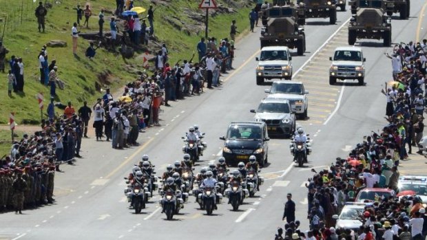 Passing by: South Africans watch the hearse carrying the coffin of Nelson Mandela on its way to Qunu.