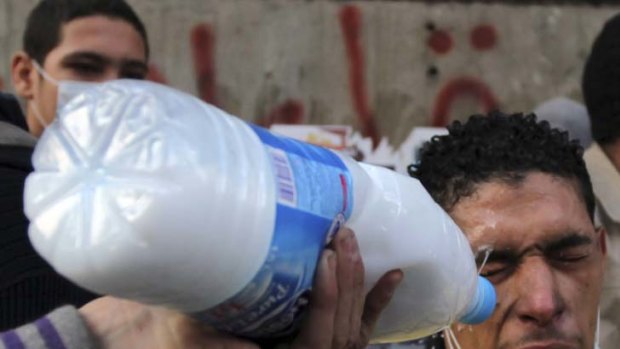 A protester has tear-gas washed from his eyes with milk.