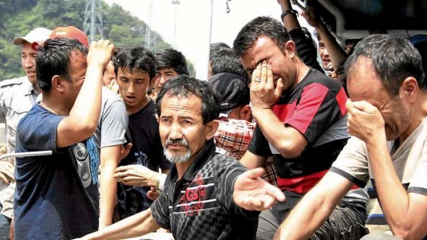 Asylum seekers from Afghanistan, Iraq and Iran cry as Indonesian officers force them to leave an Australian vessel.