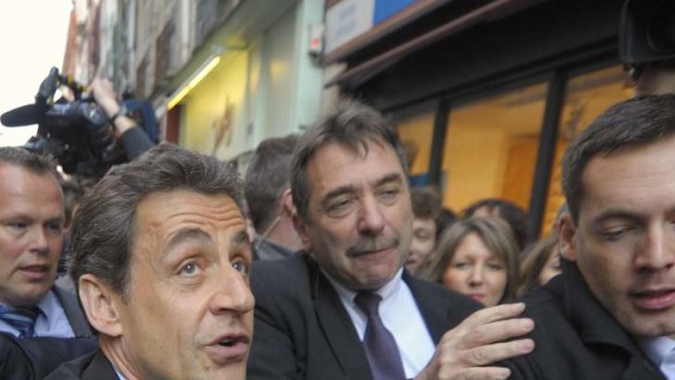 Nicolas Sarkozy walks in the street protected by plain-clothes policemen during a campaign trip earlier this month.