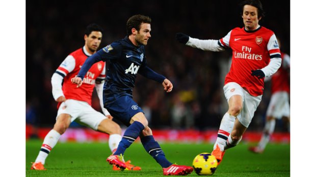 Manchester United's Juan Mata in action against Arsenal's Mikael Arteta and Tomas Rosicky.