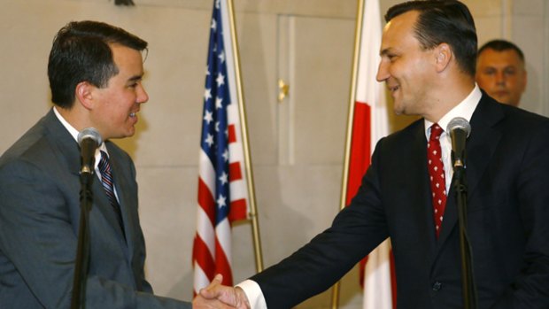 US chief negotiator John Rood (left) shakes on the deal with Polish Foreign Minister Radoslaw Sikorski.