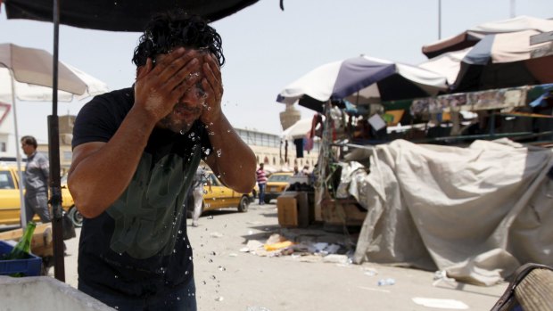 A man washes his face to cool off in Baghdad.