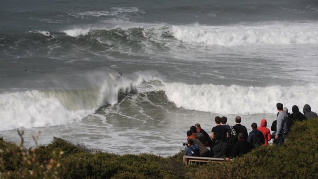 Over the top: A surfer defies a big swell at Bells Beach, keeping the watching crowd absorbed.