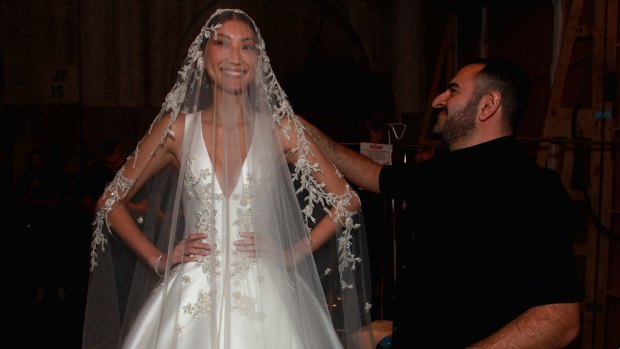 Designer Steven Khalil helps prepare a model backstage ahead of the Steven Khalil show at Mercedes-Benz Fashion Week Australia 2015. (Photo by Lisa Maree Williams/Getty Images)