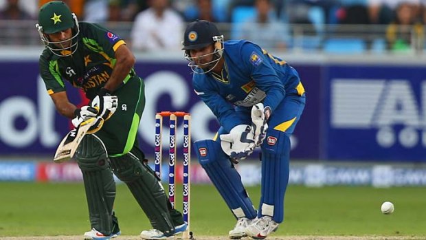 Mohammad Hafeez flicks a ball to the legside as Sri Lanka wicketkeeper Kumar Sangakkara looks on.