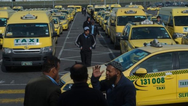 The taxi holding area at Melbourne Airport mills with drivers from every country.