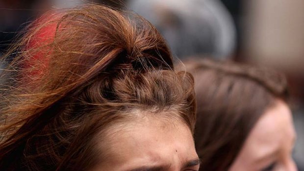 Overactive hormones ... a One Direction fan shows her emotions in Martin Place yesterday.