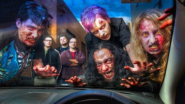 Zombie masters (rear, from left) Ben Powell, Drew Hobbs and David Leadbetter watch with satisfaction as their grisly minions assail the car of Sunday Age photographer Craig Sillitoe.