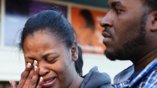 Fighting to keep ventilator on... Nailah Winkfield, mother of 13-year-old Jahi McMath, wipes her face while speaking to reporters with her husband, Martin, in front of Children's Hospital Oakland in Oakland, California.
