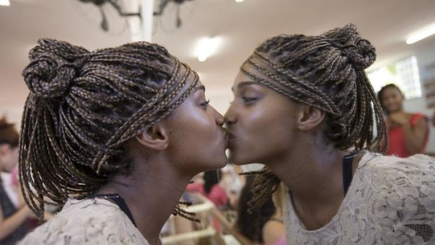 Mariana Reis, 15, kisses her reflection on a mirror before attending a debutante ball organised by the Pacifying Police Unit program, in Rio de Janeiro.