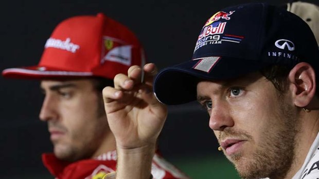 Hats on: Fernando Alonso (left) and Sebastian Vettel after the Abu Dhabi Grand Prix.