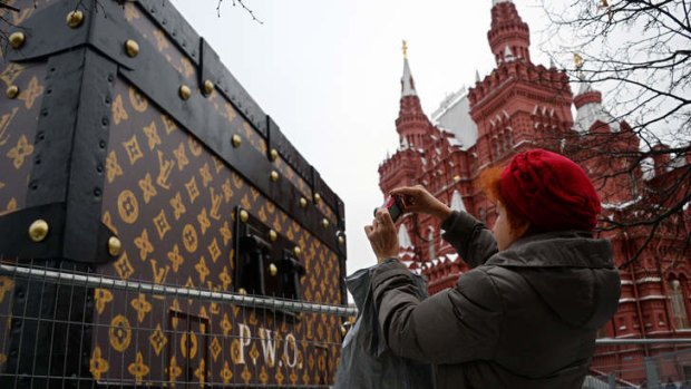 A woman takes photo of a giant Louis Vuitton trunk on Red Square in Moscow.