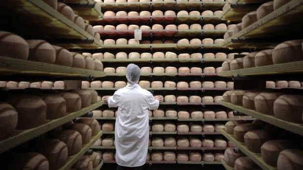 A cheesemonger checks mimolette cheese at a production site in France.