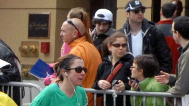 Faces in the crowd ... The Tsarnaev  brothers Tamerlan (in the black cap and Dzhokhar (in the white cap) looked like any other spectators at the Boston Marathon.