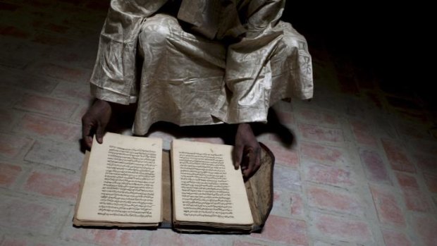 A director at the Ahmed Baba Institute, with an ancient manuscript that was saved from an attack.