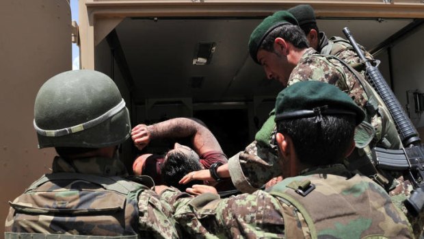 Afghan National Army soldiers remove dead and wounded civilians from the Spozhmai Hotel in Qargha lake on the outskirts of Kabul.