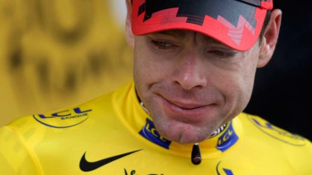 BMC rider Cadel Evans of Australia reacts on the podium with the leader's yellow jersey after the 20th time trial stage in Grenoble, during the Tour de France cycling race July 23, 2011. REUTERS/Denis Balibouse (FRANCE - Tags: SPORT CYCLING)