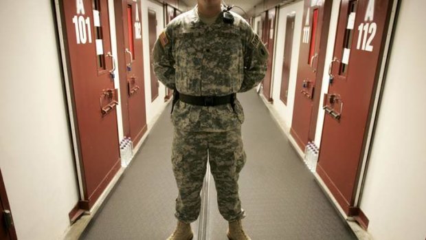 A U.S. Army guard stands in a corridor of cells in Camp Five, a facility at the Guantanamo Bay Naval Station in Guantanamo Bay, Cuba