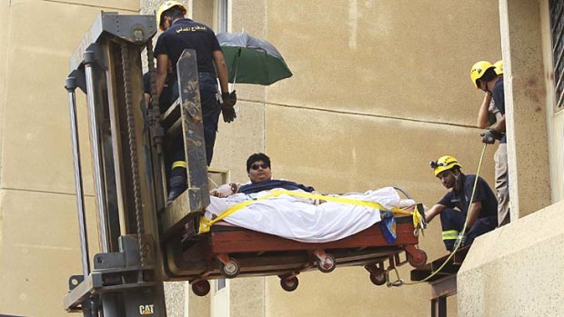Carried to hospital: a forklift removes Khaled Mohsin Shairi from his home.