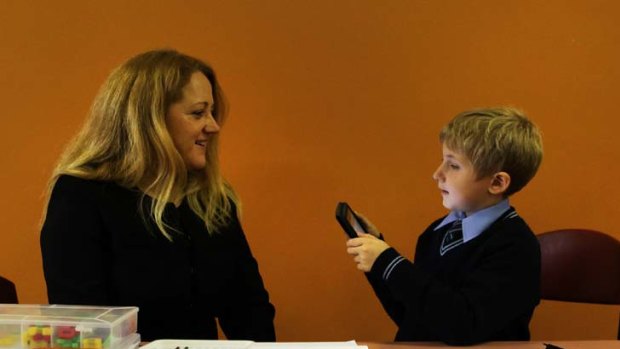Suddenly he’s much more interested ...  tutor Rachel Chaston and Dominic Risi put an iPad to good use during the reading recovery trial.