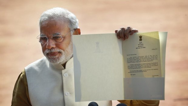 Narendra Modi displays the letter from Indian President Pranab Mukherjee inviting him to form the country's next government outside the presidential palace in Delhi.